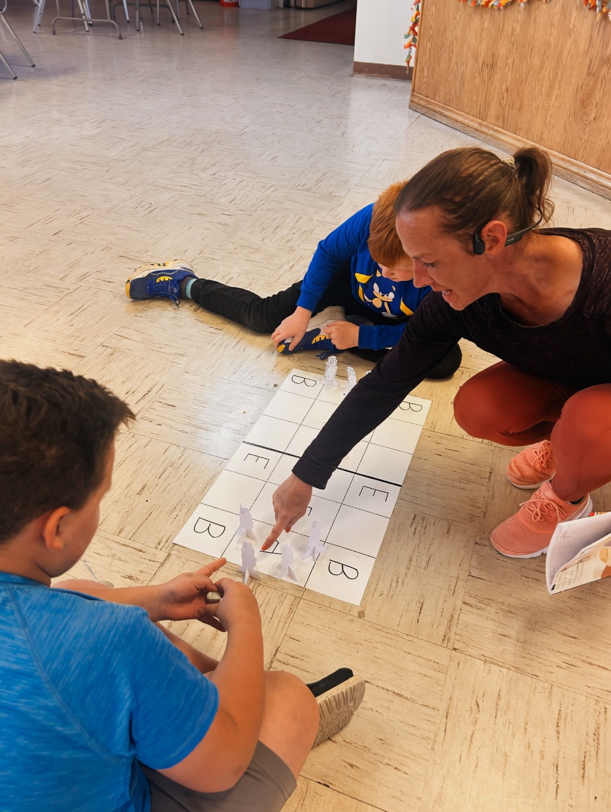 Holland Wines works on phonics with students on the floor at Room2Grow